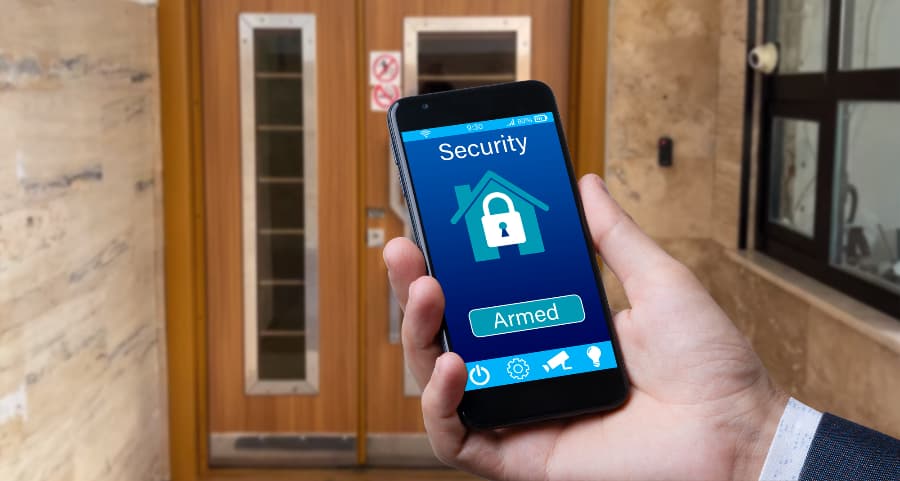 Individual using smartphone to arm a security system